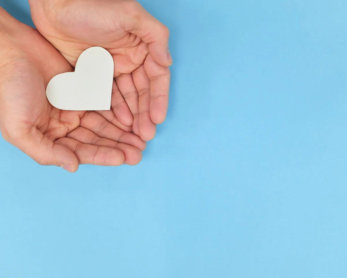 heart in hands with blue background